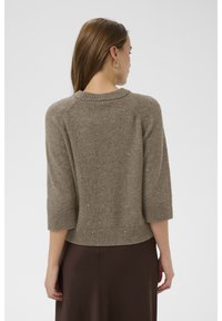 Világosbarna, kötött pulóver 3/4-es ujjakkal és kerek nyakkivágással. Texturált anyagból készült, finom csillogással és bordás szegéllyel.