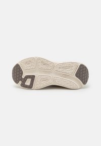 Shoe outsole featuring a beige rubber base with textured tread patterns and dark brown accents. Includes zigzag and dotted grip details.