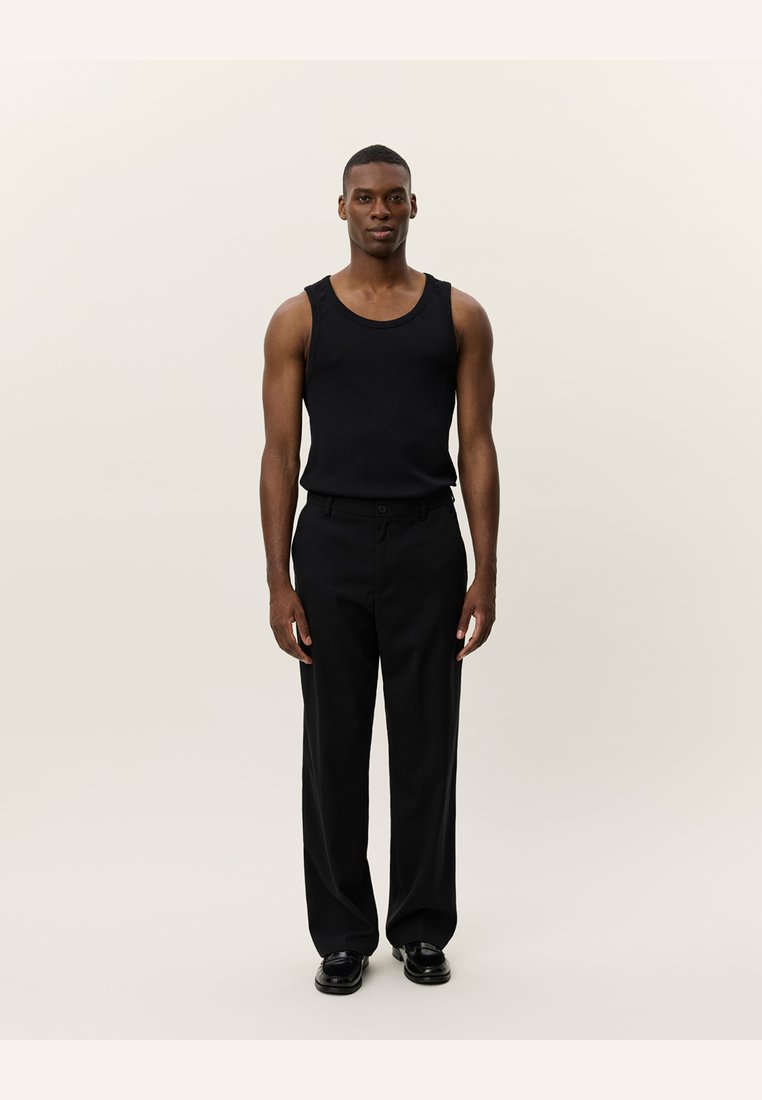 Black tank top made of a smooth, stretchy fabric, paired with black wide-leg trousers. The outfit features a simple design and relaxed fit.