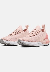 Lichtroze sport schoenen met een gestructureerde bovenkant, vetersluiting en een witte tussenzool. Beschikt over een rubberen buitenzool met een grippatroon.