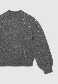 Grauer Strickpullover mit hochgeschlossenem Kragen, verziert mit verstreuten Perlen und Strasssteinen auf der Vorderseite. Lange, leicht puffige Ärmel.