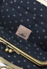 Pochette fermée en tissu bleu marine avec étoiles blanches, monture en métal doré et étiquette tissée portant l'inscription "Beck Sondergaard".