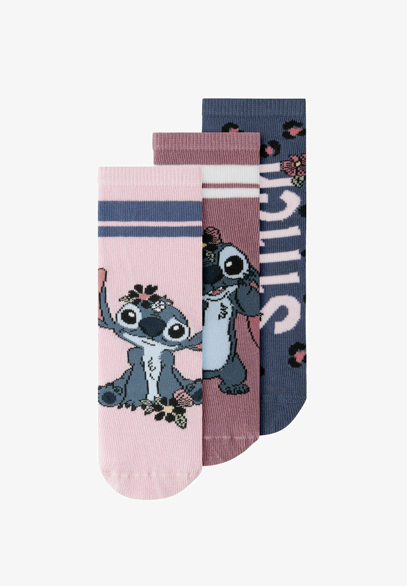 Trois chaussettes colorées pour enfants avec le personnage de dessin animé Stitch et des détails floraux, en rose, mauve et bleu marine.