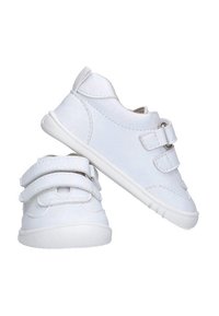 Un par de zapatillas blancas para niños pequeños con doble correa de Velcro y suelas de goma, una zapatilla en posición vertical y la otra inclinada de lado.