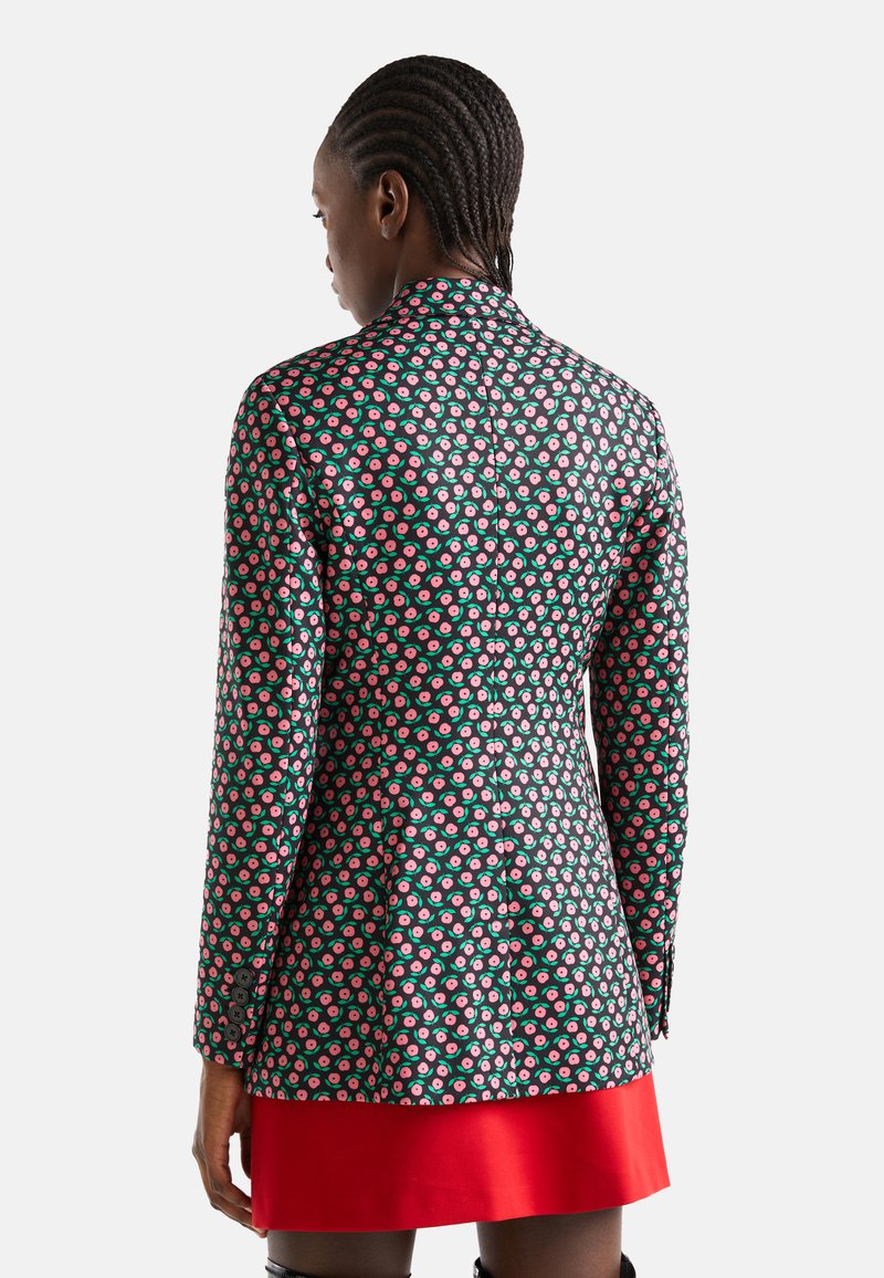 Blazer floral en noir et vert, avec un motif de fleurs roses et blanches, à un bouton, manches longues et accents de boutons.