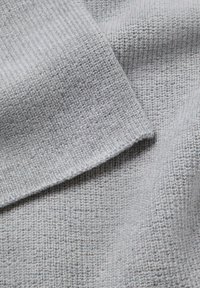 Szara dzianina o fakturowanym wzorze z załamanym brzegiem, ukazująca miękki, średniej grubości materiał. Subtelne różnice w odcieniach.