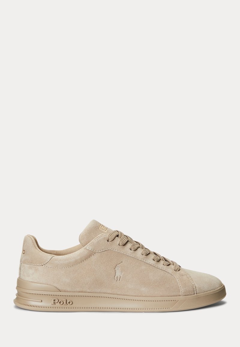 Baskets basses en daim beige avec lacets beiges, logo Polo embossé sur le côté et semelle en caoutchouc texturée sur fond blanc.