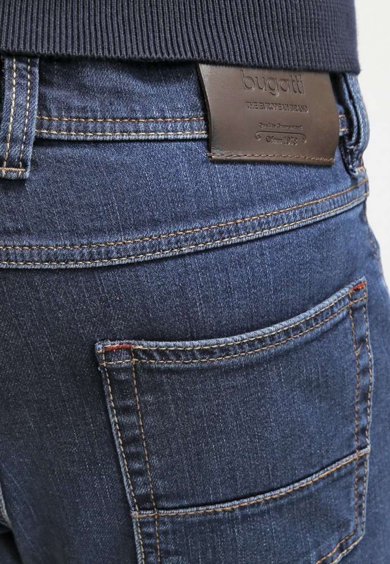 Dunkelblaue Jeans aus Denim mit strukturierter Oberfläche. Mit einem Lederpatch am Bund und kontrastierenden Nähten. Zwei Gesäßtaschen.