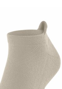 Beige Knöchelsocke mit strukturiertem Strickmuster, einer glatten, abgerundeten Kante und einer kleinen Schlaufe auf der Rückseite für ein einfaches Anziehen.
