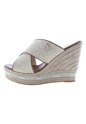 Infradito beige con zeppa e cinturini incrociati, suola in juta intrecciata e un accento decorativo con logo argento. Sottopiede liscio simile alla pelle.