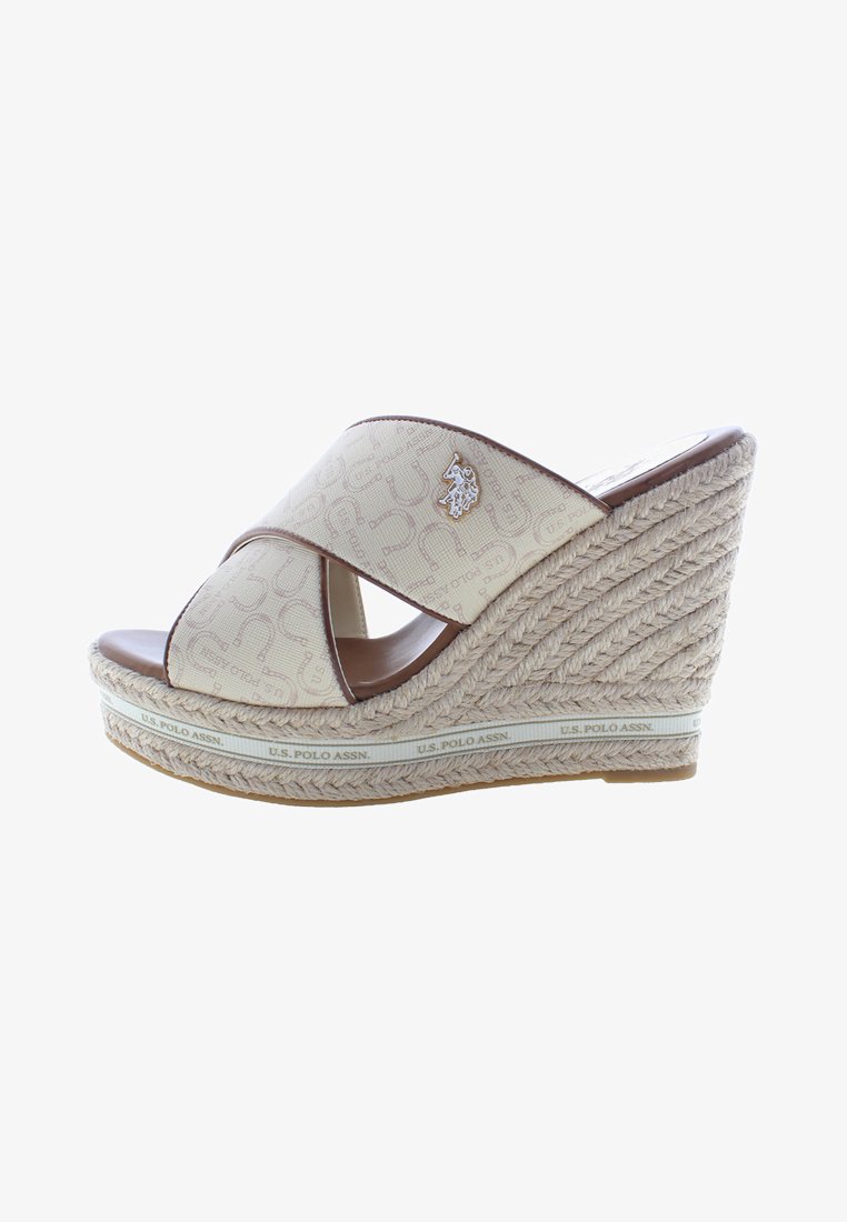 Infradito beige con zeppa e cinturini incrociati, suola in juta intrecciata e un accento decorativo con logo argento. Sottopiede liscio simile alla pelle.