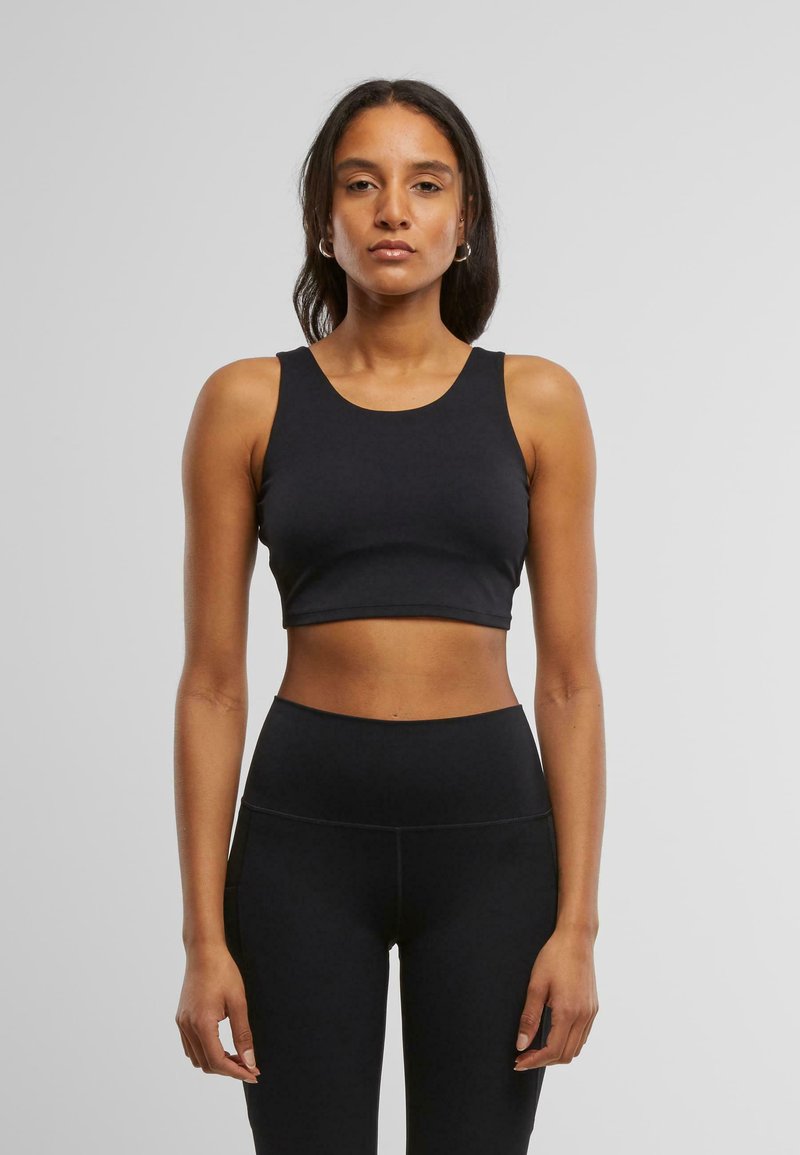 Svart, kort athletic topp med rund hals og tykke stropper, laget av et glatt, elastisk materiale, sammen med matchende høy midje tights.