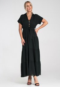 Czarna, warstwowa maxi sukienka z zapięciem na guziki z przodu, krótkimi rękawami i paskiem w talii. Wykonana z lekkiego materiału o zwiewnym kroju.