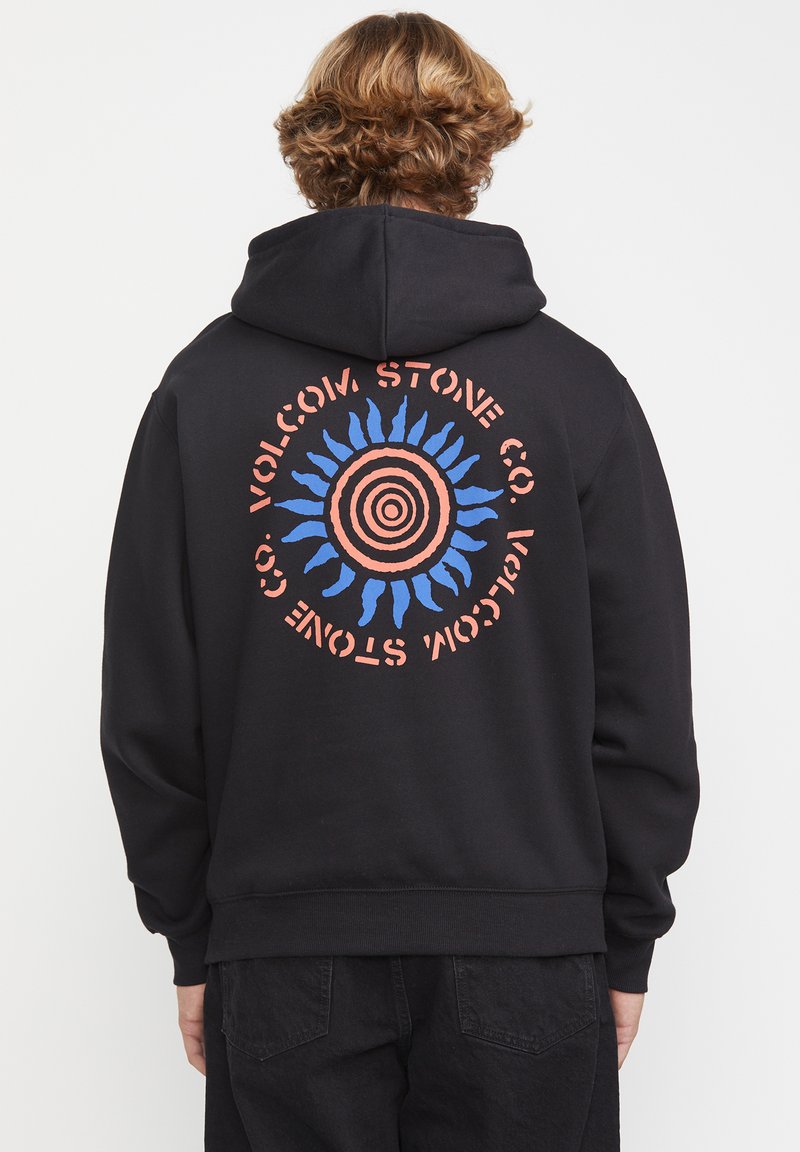Felpa nera con cappuccio, caratterizzata da una grafica circolare sulla schiena, che mostra un design a raggiera blu e corallo con la scritta "VOLCOM STONE CO.".