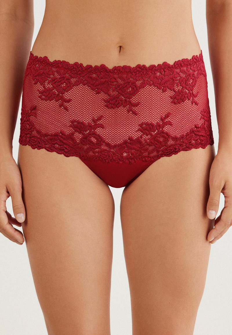 Rote Spitzenunterwäsche mit einem Blumenmuster am Bund, darunter glattes Material für Komfort und Bedeckung.