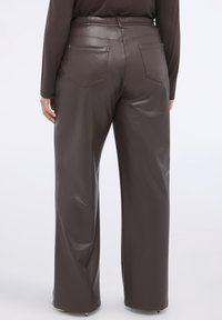 Bruine imitatieleren wijduitlopende broek met een hoge taille en twee achterzakken. Glad oppervlak met een glanzende afwerking.