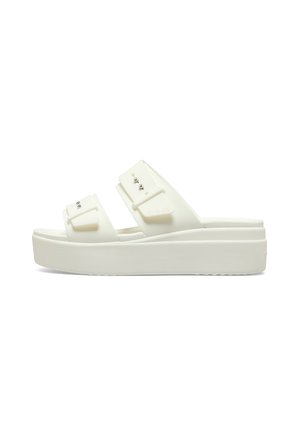 White platform sandals with two wide straps featuring buckle accents and metal studs. Made of durable material, smooth texture.