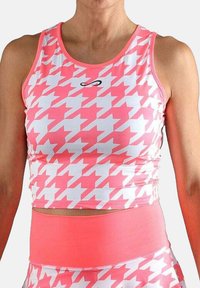 Mujer vestida con un top corto de cuadros en rosa y blanco y leggings deportivos de cintura alta a juego, contra un fondo blanco.