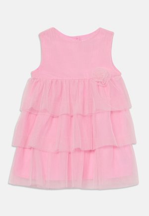 Robe rose pour bébé sans manches avec jupe en tulle à trois couches et petite fleur en tissu sur la poitrine, vue de face sur fond blanc.