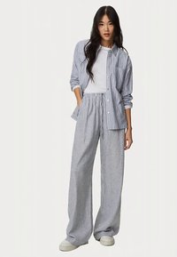 Sada s proužkovanou košilí a širokými kalhotami v modré a bílé barvě. Bavlněná látka, volný střih, zapínání na knoflíky, pružný pas a bez kapes.