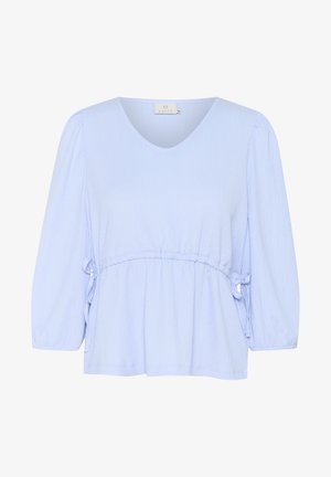 Blouse bleu clair avec un décolleté en V, des manches trois-quarts et un détail de taille froncée. Tissu doux et texturé avec des liens latéraux pour réglage.