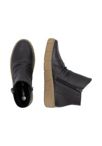 Bottines en cuir noir avec une finition texturée, dotées d'une fermeture éclair sur le côté et d'une semelle en caoutchouc beige au design segmenté.