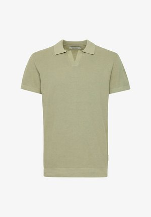 Polo à manches courtes en tissu tricoté vert clair avec un col en V, un col contrasté et des détails en bords côtes.