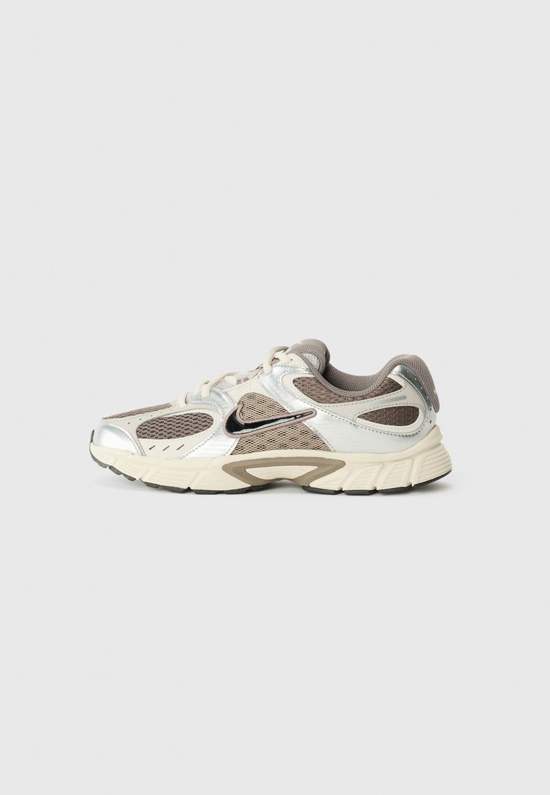 Buty sportowe w odcieniach beżowym, szarym i metalicznie srebrnym. Posiadają siateczkowe panele, wyściełaną podeszwę oraz czarne akcenty. Okrągły czubek i wyściełany kołnierz.