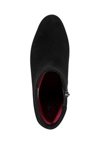 Stivale alla caviglia in suede nero con punta arrotondata, fodera rossa interna, dettaglio con zip laterale e texture liscia. La forma appare aderente e slanciata.