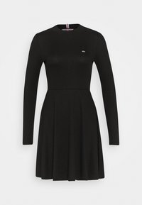 Svart ribbad långärmad klänning med figurnära midja och utsvängd kjol, med en liten Tommy Jeans-logotyp på bröstet.