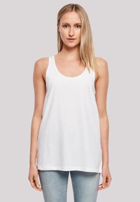 White sleeveless tank top made of light fabric, featuring a round neck and an elongated cut, worn with light blue jeans.