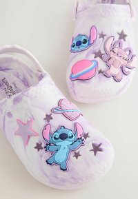 Saboturi violet deschis cu un design marmorat, decorate cu elemente din cauciuc colorate: stea, planete și personaje de desene animate.