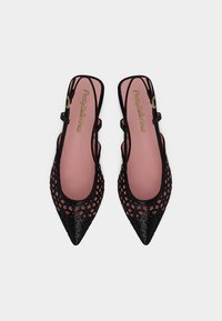 Μαύρα μυτερά slingback flats με γεωμετρικό μοτίβο κοψίματος και ροζ πάτους με την ένδειξη Pretty Ballerinas, απεικονισμένα από πάνω.