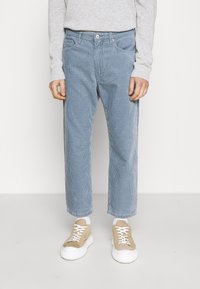 Pantaloni in velluto a coste blu chiaro con taglio dritto, caratterizzati da sottili righe verticali, cinque tasche e chiusura con bottone in vita.