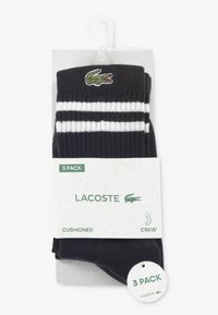 Μαύρες κάλτσες για πλήρωμα σε πακέτο των τριών, με λευκές ρίγες, μαξιλαρωτή σχεδίαση και πράσινο λογότυπο Lacoste στο επάνω μέρος.