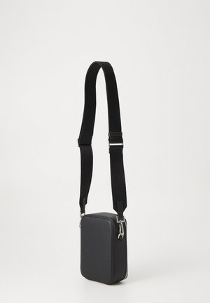 Black rectangular crossbody bag with a textured surface, adjustable strap, silver hardware, and a zip closure.