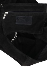 Zwarte suède tas met een ritszak en een leren label. Voorzien van zilveren kettinghardware en een zachte textuur. Het interieur is ruim en gevoerd.