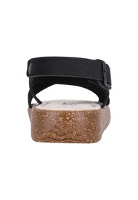 Svart mockasandal med bred rem, justerbar spänne och en korktexturerad kilklack. Har en formad innersula för komfort.