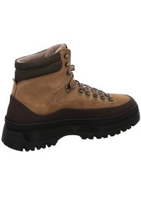 Botte de randonnée en daim marron avec semelle épaisse en caoutchouc noir, col rembourré à la cheville, œillets en métal et lacets rayés.