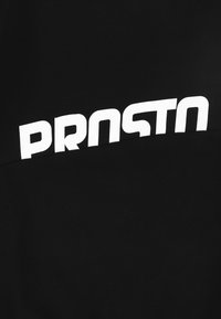 Czarna bluza z wyraźnym białym logo "PROSTO" na piersi. Miękka tekstura tkaniny, z odważnym, nowoczesnym krojem czcionki.