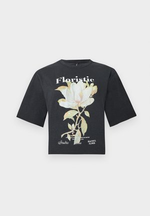 Μαύρο oversized t-shirt με μεγάλο λευκό και πράσινο λουλουδάτο σχέδιο και κείμενο "Floristic" και "Beautiful Flower" στο μπροστινό μέρος.