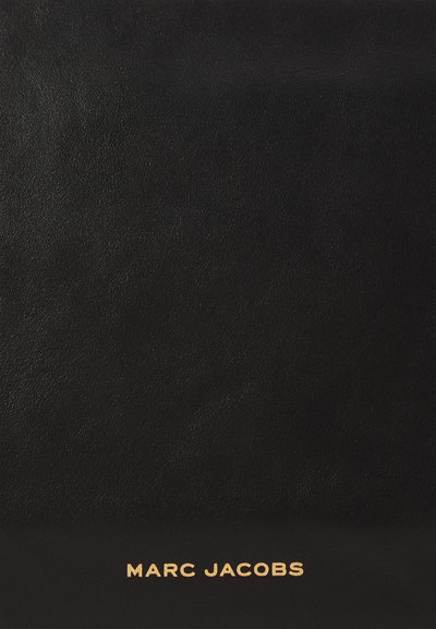 Schwarze Lederhandtasche mit glatter Textur. Besitzt ein goldenes "MARC JACOBS"-Logo am Boden. Einfaches Design, rechteckige Form.