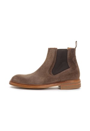 Botas de tobillo de ante marrón con paneles laterales de elástico y una lengüeta, que presentan una suela de cuero suave y un diseño de punta redonda.