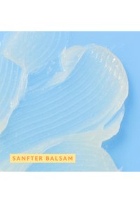 Clear gel substance with a smooth texture, featuring subtle ridges, against a pale blue background. Label reads "SANFTER BALSAM."