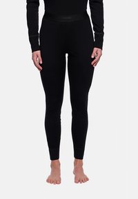 Leggings noirs en tissu extensible, dotés d'une ceinture plate avec le logo "VAUDE". Texture lisse et coupe ajustée, se terminant aux chevilles.