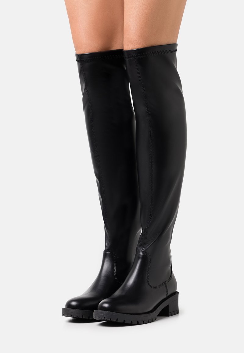 Svarta läderstövlar i höjd med låren med en slät yta, rund tå och texturerad gummisula. Har en elegant, åtsittande design med stickade detaljer.