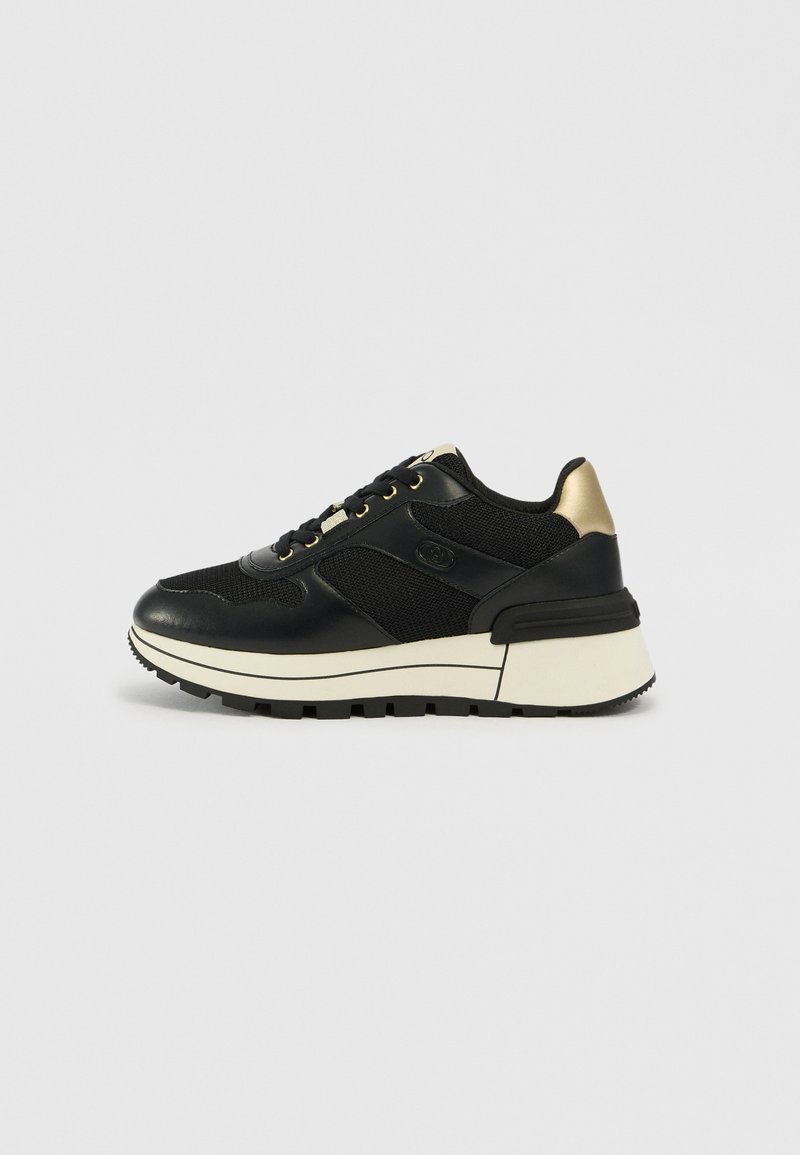 Schwarze Sneaker mit einer Kombination aus Leder und Mesh-Materialien, goldenen Akzenten, einer robusten weißen Sohle und einem markanten Profil.