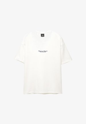 T-shirt en coton blanc avec un col rond et des manches courtes. Le devant affiche le texte "Maître des Maîtres" en bleu marine.