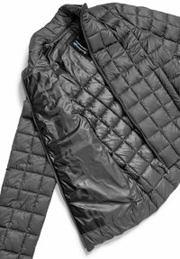 Giacca nera trapuntata con un'esterno lucido e texturizzato e una fodera interna liscia. Include una chiusura con zip e un'etichetta con il marchio visibile.
