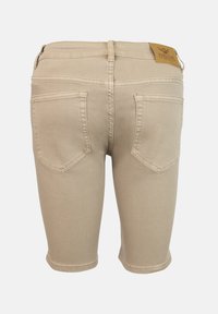 Pantalones cortos de mezclilla beige con un diseño ajustado. Cuenta con dos bolsillos traseros y una etiqueta de cuero en la cinturilla. Textura suave y costuras limpias.